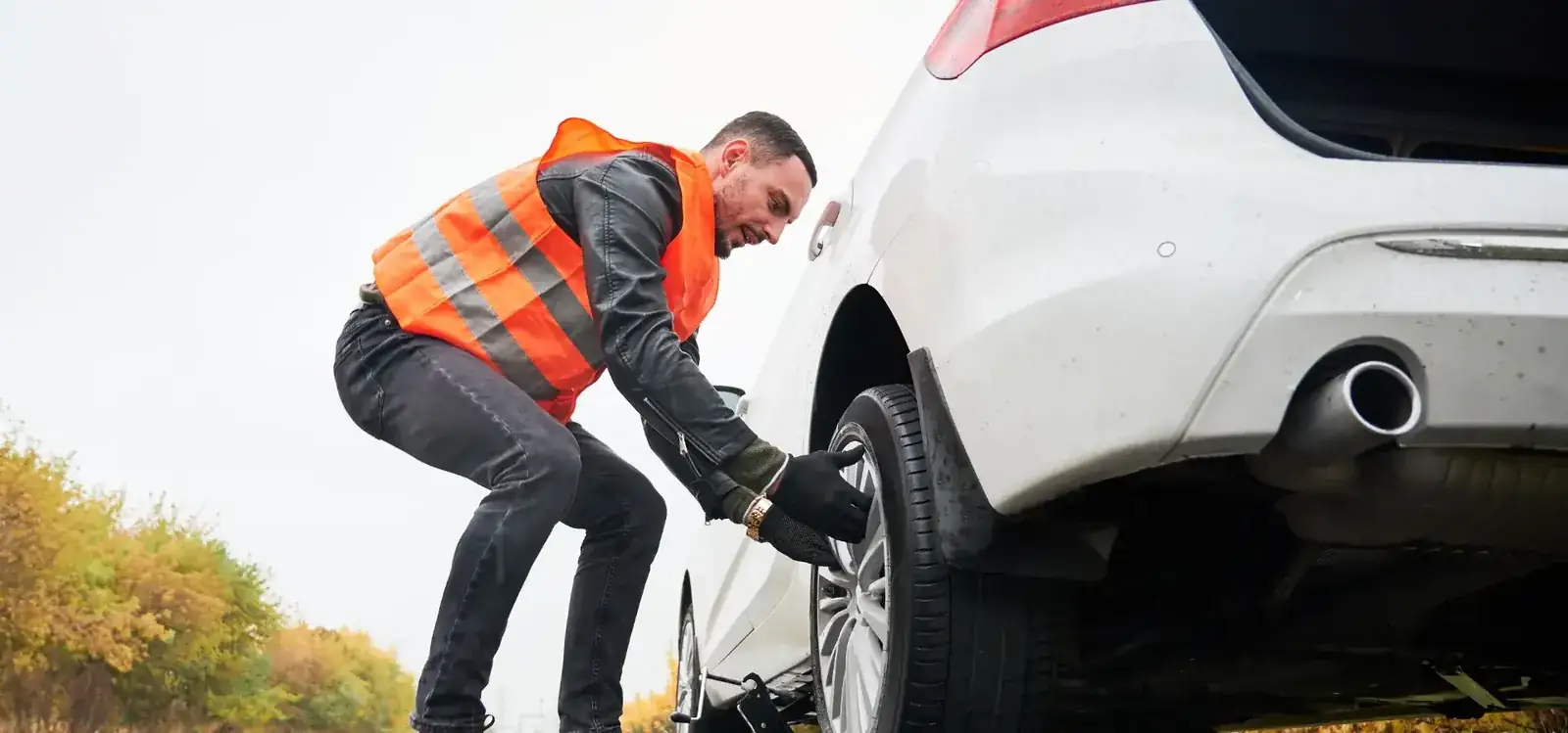 Reflektif yelekli ekip otomobil lastiğini yerinde değiştiriyor